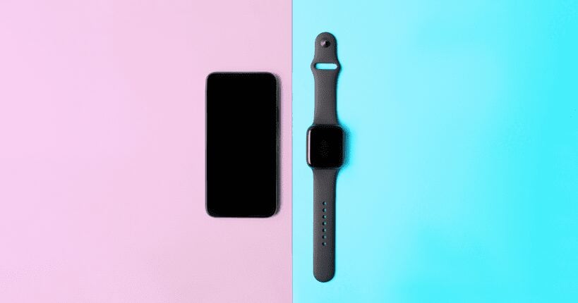 An iPhone placed on pink background and Apple Watch placed on blue background