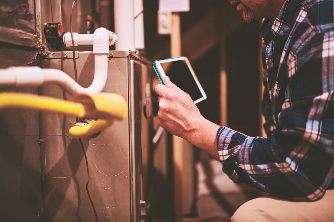 Home Appraiser or Home Inspector using digital tablet in furnace room