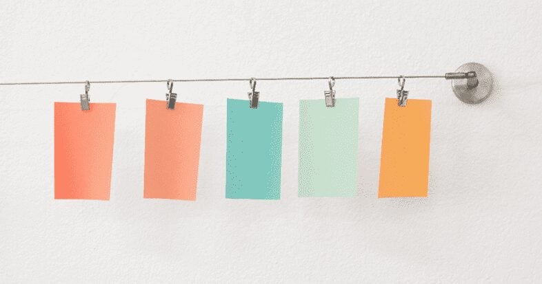 pieces of colorful paper hanging on a line