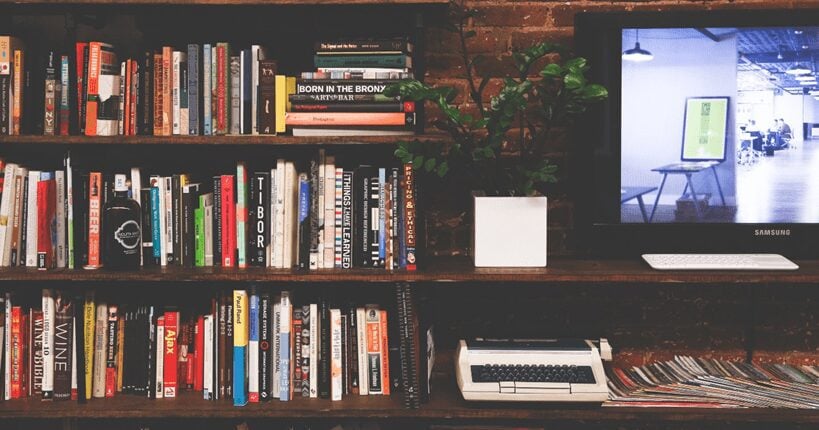 books and a typewriter on a shelf