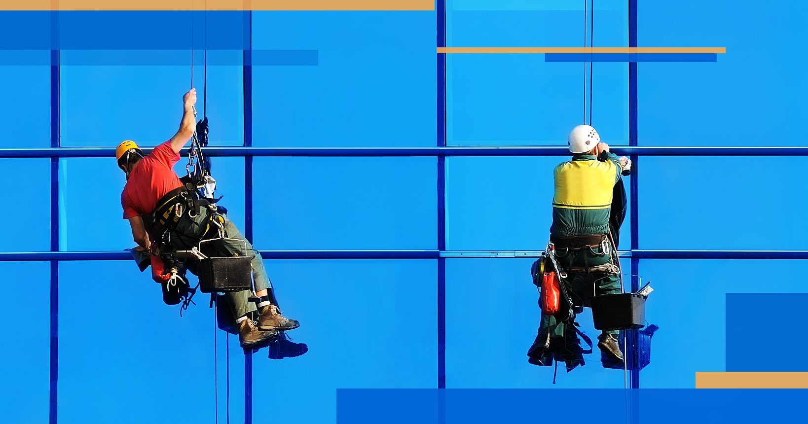 Two window cleaners hanging on ropes cleaning a facility