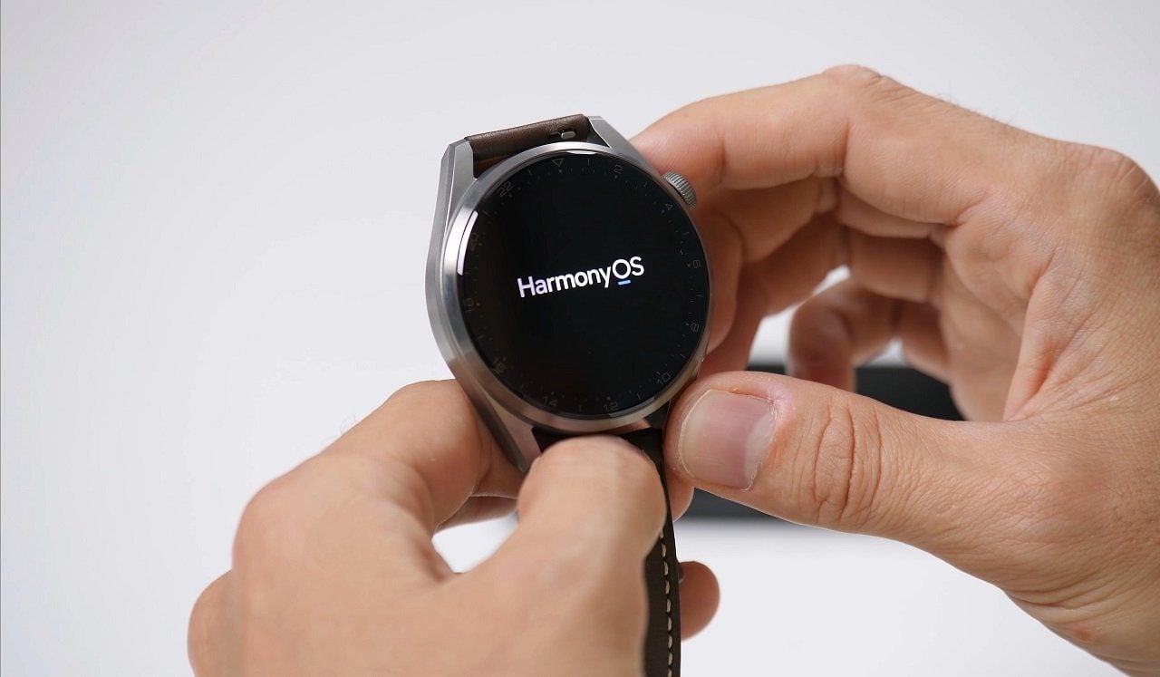 A person holding Huawei Watch 3 Pro smartwatch with HarmonyOS running