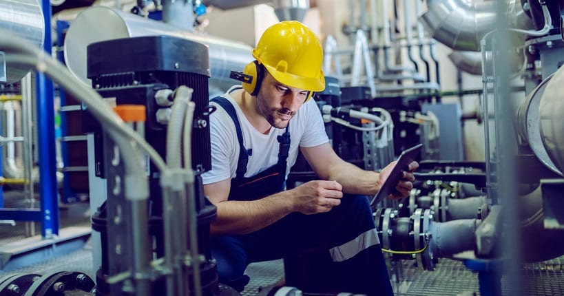 Focused technician using tablet for checking machine