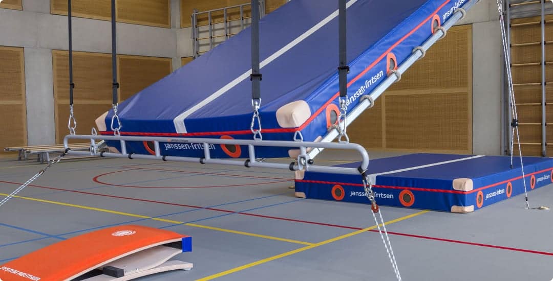 a gym with a ladder and a mat on the ground