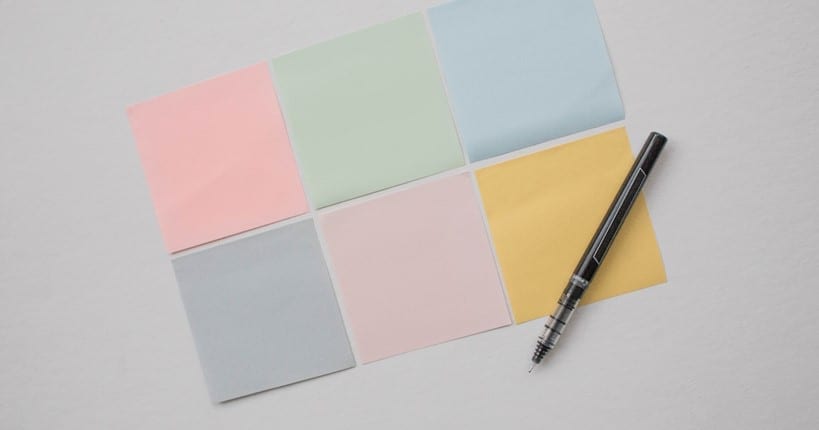 colorful sticky notes and pen on white background