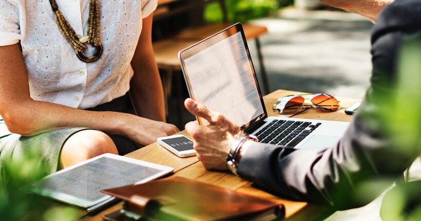 man and woman working on computer and tablet