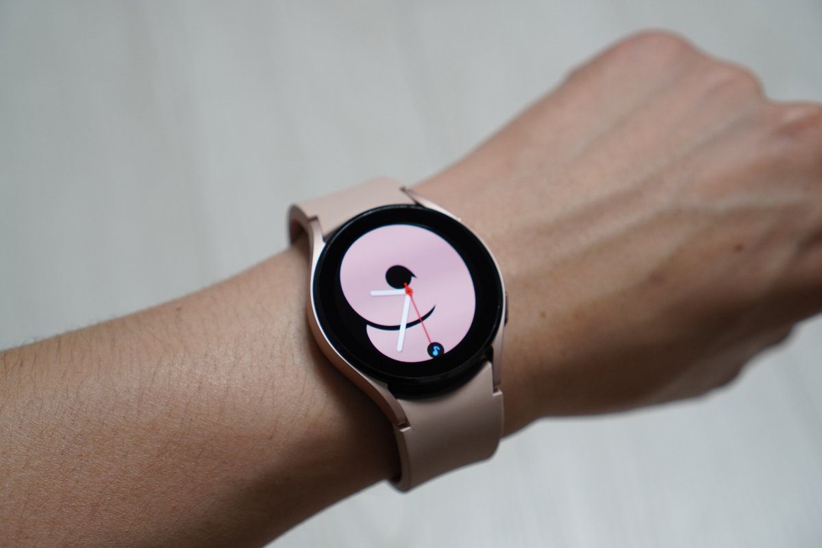 Samsung Galaxy Watch 4 with black and pink watchface on a wrist