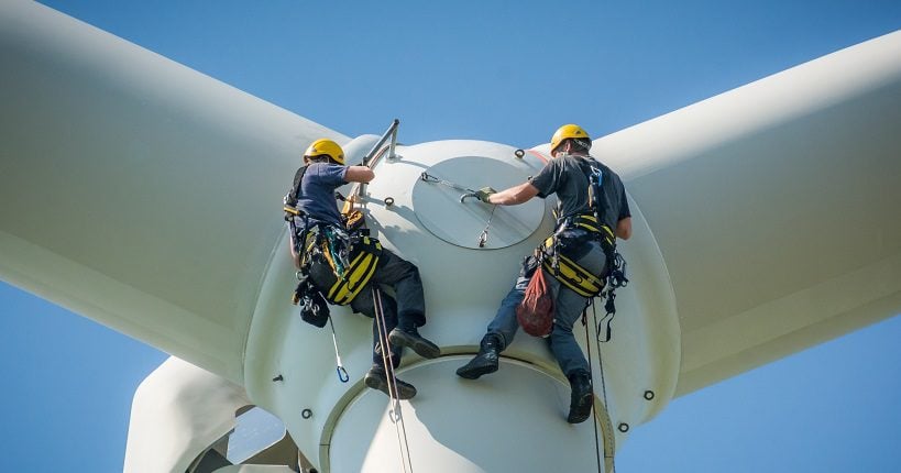 Two technicians maintaining a wind turbine